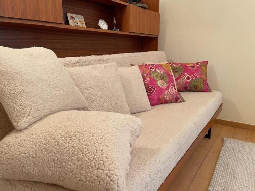 a couch with pillows on it in a room at Petit appartement au rez in Baulmes