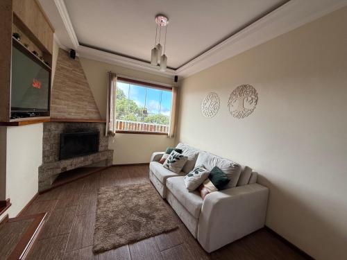 a living room with a couch and a fireplace at Casa para até 8 pessoas ou studio para até 3 com fácil acesso à pontos turísticos in Campos do Jordão
