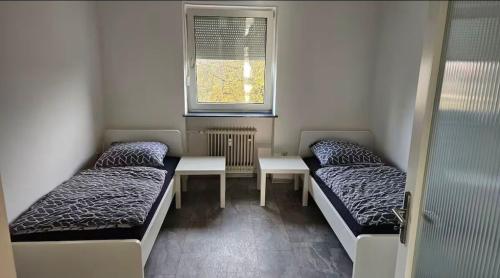 Una habitación con dos camas y una mesa y una ventana. en Malatya, en Burgkirchen an der Alz