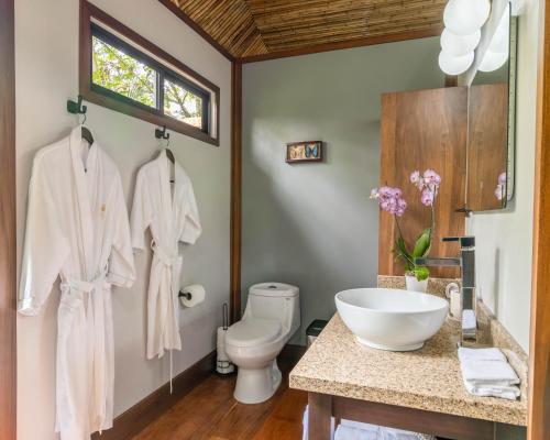 a bathroom with a sink and a toilet at Secret Bungalows Lechu in Chachagua
