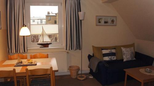 ein Wohnzimmer mit einem Sofa, einem Tisch und einem Fenster in der Unterkunft Ferienwohnungen Bütow in Wismar