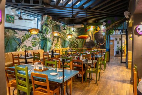 a restaurant with tables and chairs and a mural at Hotel Posada De Roger - Near Los Muertos Beach in Puerto Vallarta