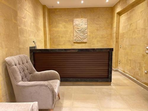 a living room with a fireplace and a chair at Mirage pyramids view hotel in Cairo