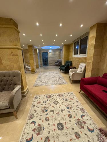 a living room with a red couch and a rug at Mirage pyramids view hotel in Cairo