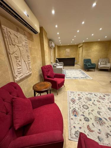 a living room with red furniture and a piano at Mirage pyramids view hotel in Cairo