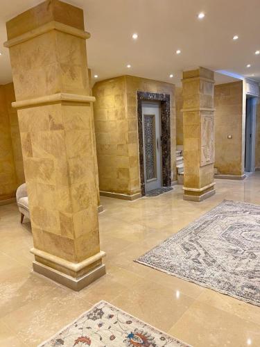 a large room with columns and a rug on the floor at Mirage pyramids view hotel in Cairo