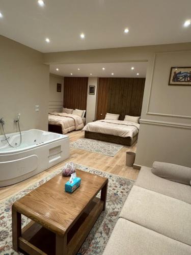 a large bathroom with a tub and two beds at Mirage pyramids view hotel in Cairo