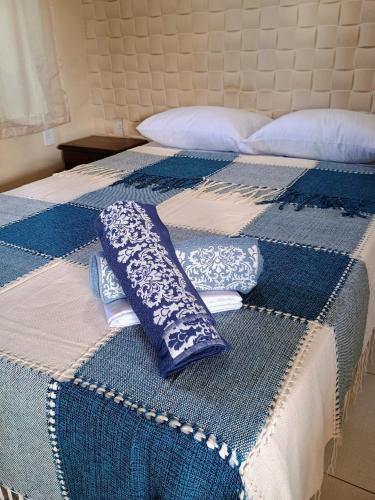 a blue and white bed with pillows on it at Flats Mundos Pipa in Pipa