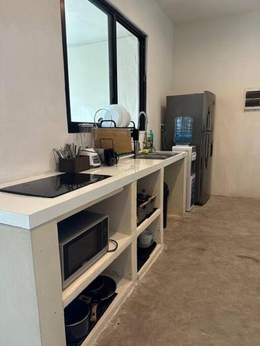 a kitchen with a counter with a sink and a window at Residencia en Celestún Casa Kaanab in Celestún