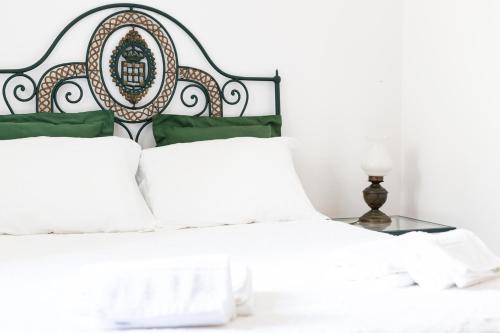 1 dormitorio con cama blanca y cabecero negro en Casa do Cipreste, en Viana do Castelo