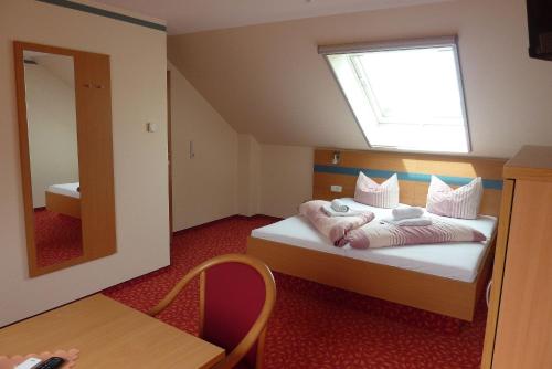 a bedroom with a bed with a window and a mirror at Spreewald Pension Spreeaue in Burg
