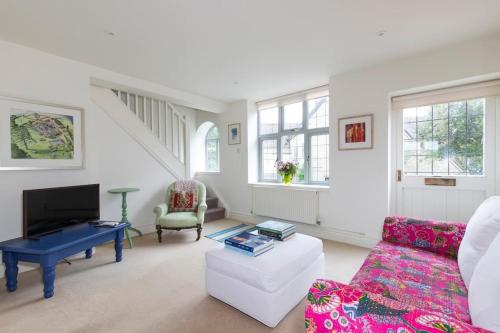 een woonkamer met een bank en een tafel bij Cotswold Stable Cottage in Bibury