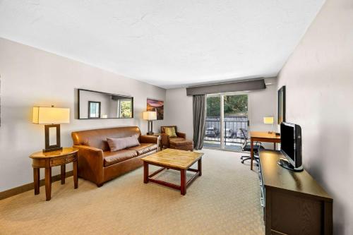 a living room with a couch and a television at Best Western Inn at the Rogue in Rogue River