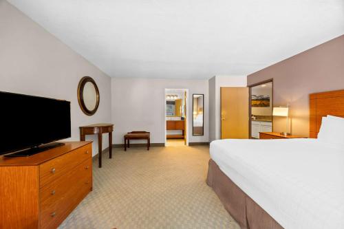 a hotel room with a bed and a flat screen tv at Best Western Inn at the Rogue in Rogue River