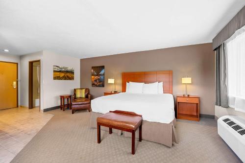 a hotel room with a bed and a chair at Best Western Inn at the Rogue in Rogue River