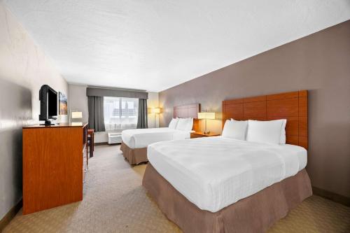 a hotel room with two beds and a television at Best Western Inn at the Rogue in Rogue River