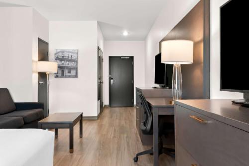 a hotel room with a desk and a couch at Best Western Plus Morden in Morden