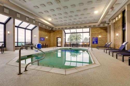 a pool in a building with chairs and tables at Drury Inn & Suites Cape Girardeau in Cape Girardeau
