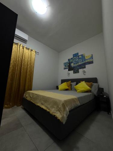 a bedroom with a bed with yellow pillows at Pozzuoli Seaview in Pozzuoli