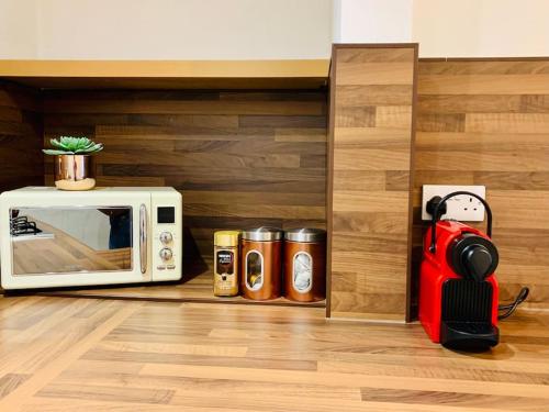 eine Mikrowelle auf einem Regal neben einer Küche in der Unterkunft Quiet apartment close to station & Stirling Castle in Stirling