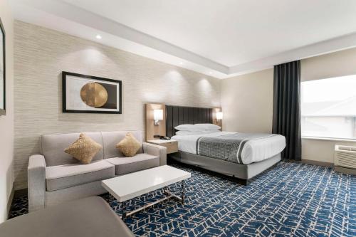 a hotel room with a bed and a couch at Best Western Premier Route 97 Vernon in Vernon