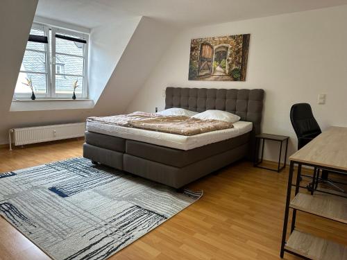 a bedroom with a bed with a rug and a table at City Wohnung Zwickau in Zwickau