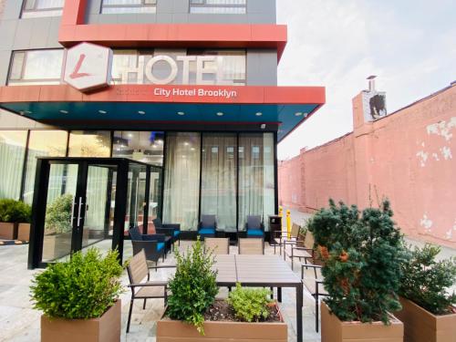 a building with tables and chairs in front of a building at The L Hotel in Brooklyn