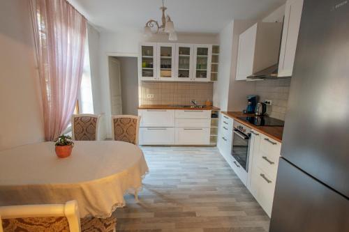 une cuisine avec une table et des placards blancs dans l'établissement La Cure, à Wintzenheim