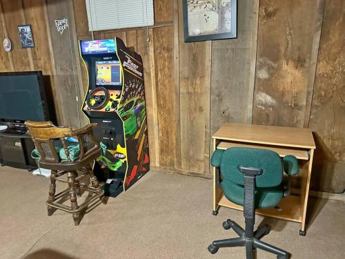 a room with a desk and a chair and a video game at Buffalo Playhouse with game room in Williamson