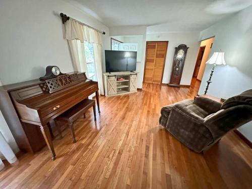 a living room with a piano and a couch at Buffalo Playhouse with game room in Williamson