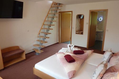 a room with a bed with pillows and a staircase at Spreewald Pension Spreeaue in Burg