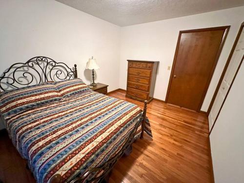 a bedroom with a bed and a dresser and a door at Buffalo Playhouse with game room in Williamson