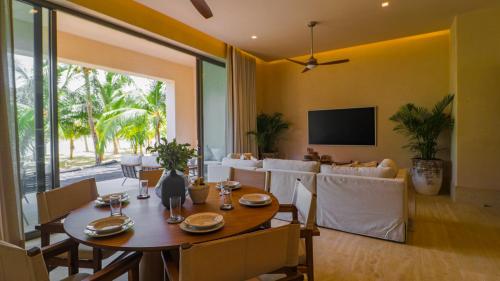 a dining room with a table and a couch at Artila Beach Condos, Isla Mujeres in Isla Mujeres
