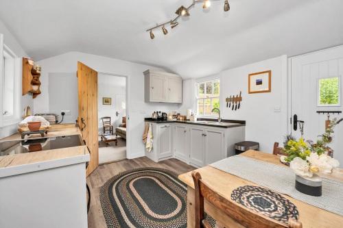 a kitchen with white cabinets and a table in a kitchen at The Red Shed Entire home for 2 Private garden and parking 2 miles from Bury St Edmunds in Whepstead
