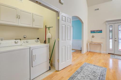 Waterfront Oak Island Home with Dock في أوك آيلاند: مطبخ مع خزائن بيضاء وغسالة ومجفف