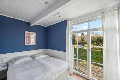 a bedroom with a bed and a large window at Landhaus Köhn in Giekau