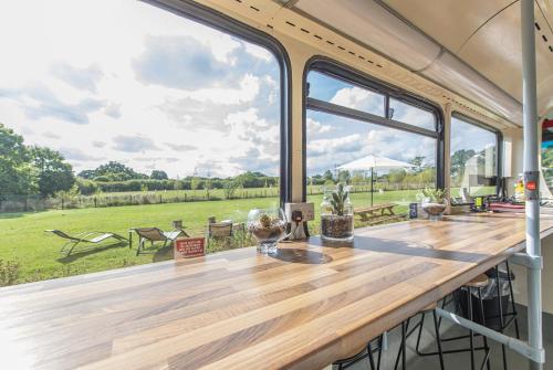 a large table with a view of a field at Double Decker Bus on an Alpaca farm sleeps 8, 5 mins drive to Dartmoor in Bovey Tracey