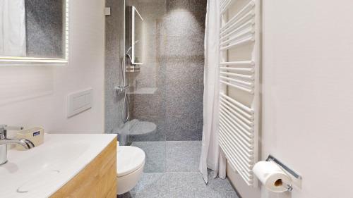 a white bathroom with a toilet and a shower at Abitaziun Landignas - Zuoz in Zuoz