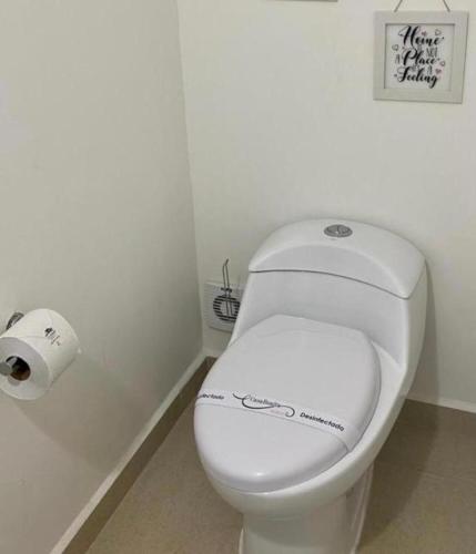 a bathroom with a white toilet and a roll of toilet paper at CASABONITA fte alberca, AirAc in Alpuyeca