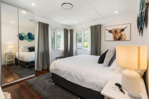 ein Schlafzimmer mit einem Bett mit einer Kuh an der Wand in der Unterkunft Acacia Ridge Cottage - Firepit, Kids Cubby, Games in Brisbane