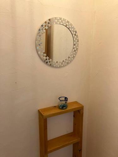 a mirror on a wall next to a wooden table at ほしなや in Nagano