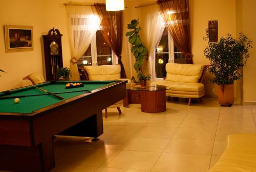 a living room with a pool table and chairs at Hotel Passione in Bielsko-Biala