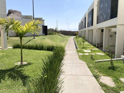 a sidewalk next to a building with a palm tree at CASABONITA fte alberca, AirAc in Alpuyeca
