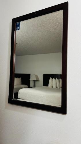 a mirror on a wall with a bed in a room at Days Inn by Wyndham North Platte in North Platte