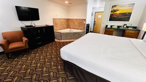 a hotel room with a bed and a bath tub at Days Inn by Wyndham North Platte in North Platte