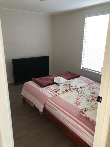 a bedroom with a bed and a window and a television at Home Away From Home in Melbourne