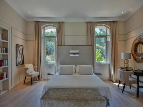 a bedroom with a large bed and two windows at Villa in Ibiza with Cala Moli Beach Access in Valdepeñas