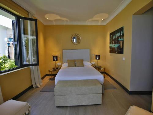 a bedroom with a large bed and a couch and a window at Villa in Ibiza with Cala Moli Beach Access in Valdepeñas