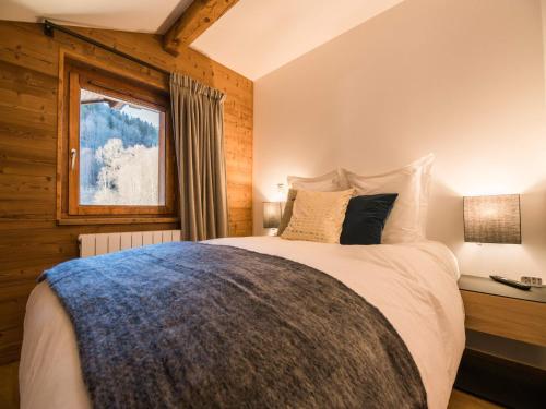 une chambre avec un grand lit avec une fenêtre dans l'établissement Wood & Stone Alpine Luxury, à Praz-sur-Arly