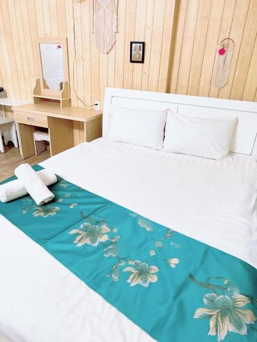 een slaapkamer met een bed met een blauwe en witte sprei bij Khách sạn Trí Đức in Da Lat
